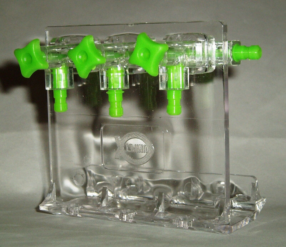 Unipet clear acrylic 3-way aquarium gang valve divider with green control knobs and outlet barbs, shown on a stand