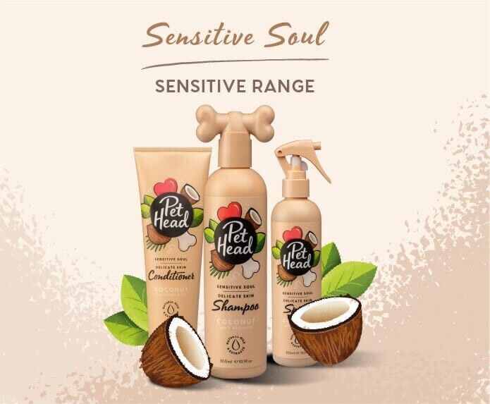 Pet Head Sensitive Soul range — shampoo, conditioner and spray bottles arranged together with coconut and leaf decorations on a warm beige background.