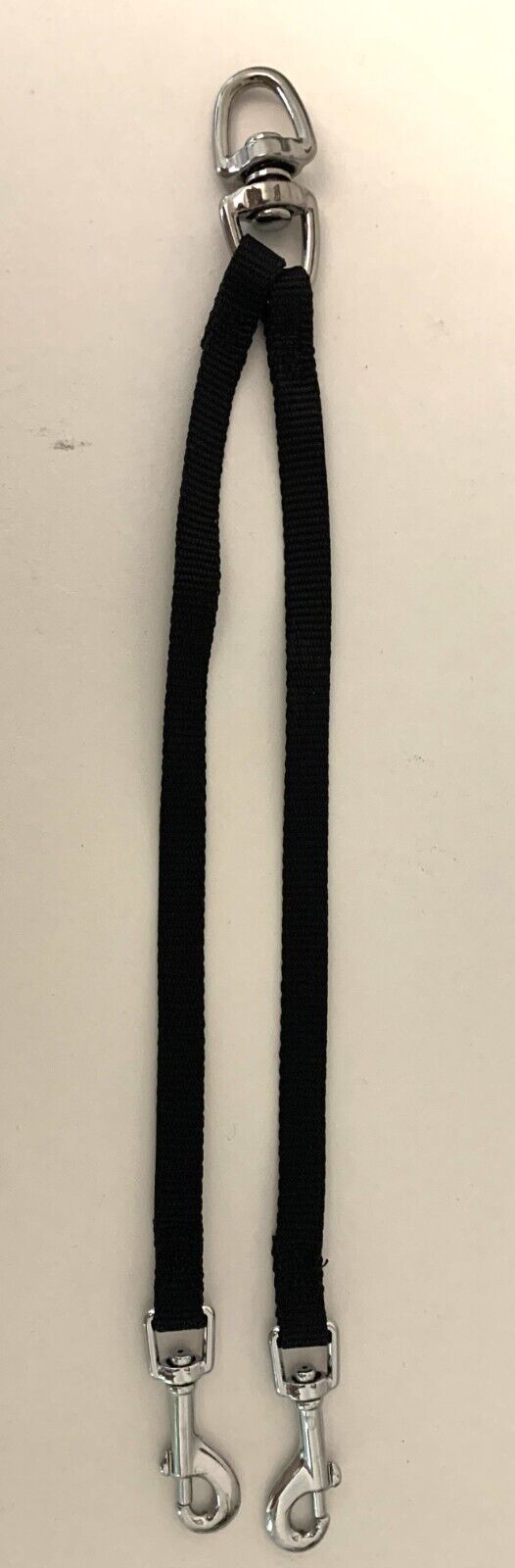 GoPetPlace black nylon dog coupler with swivel lead attachment and two snap clips, laid flat on white surface