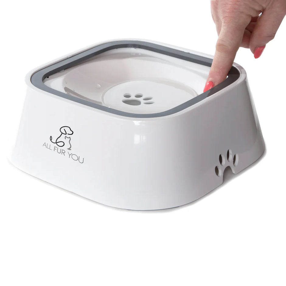 A hand pressing down on the floating disc of the All Fur You white anti-splash pet water bowl, demonstrating how the disc moves under pressure.