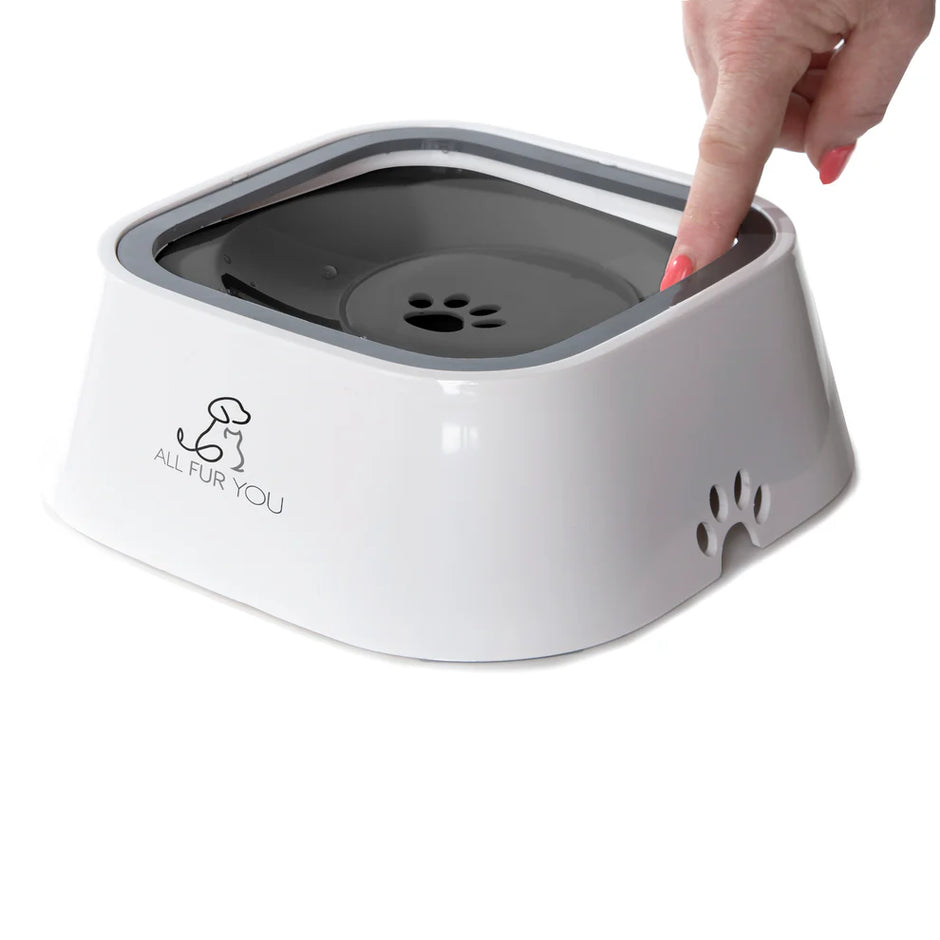 A hand pressing down on the floating disc of the All Fur You grey anti-splash pet water bowl, demonstrating how the disc moves under pressure