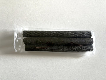 Three dark brown beef liver sticks sealed in a clear plastic pack, shown from above against a white background.