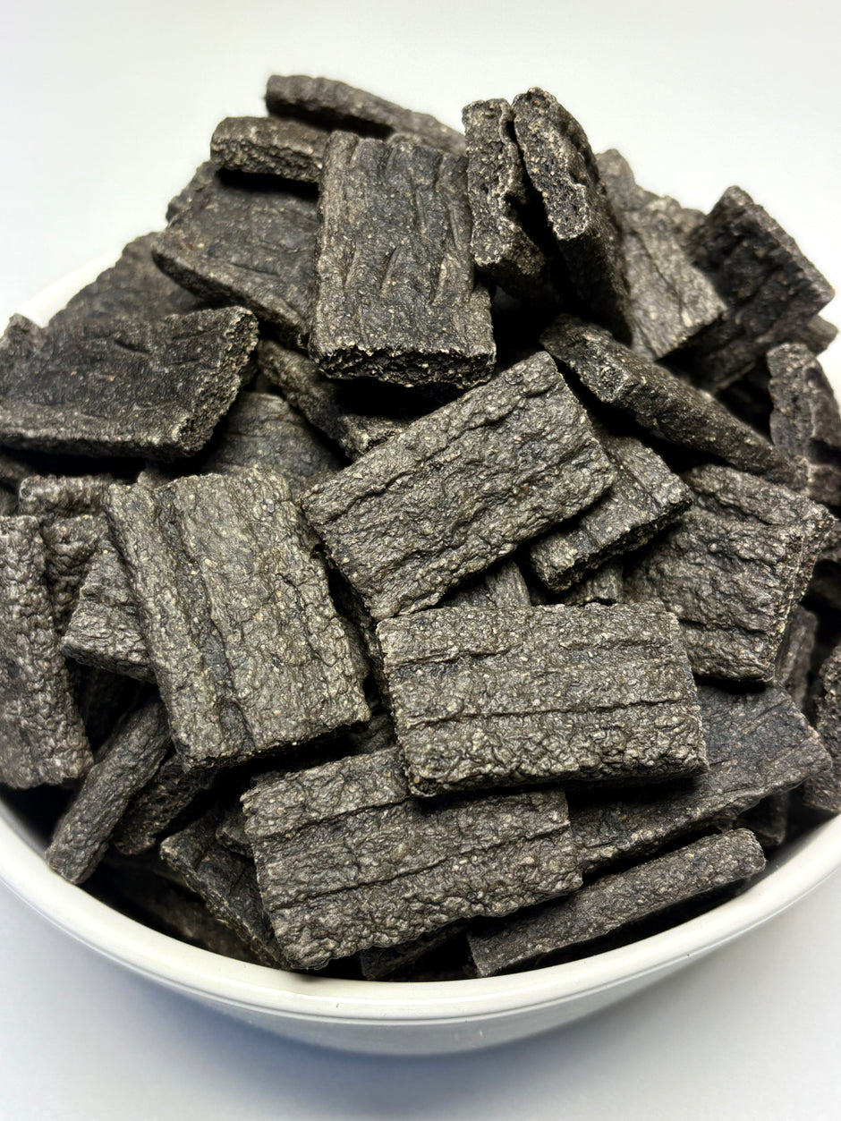 White bowl filled with GoPetPlace beef liver BBQ chips — dark, textured crinkle-cut pieces