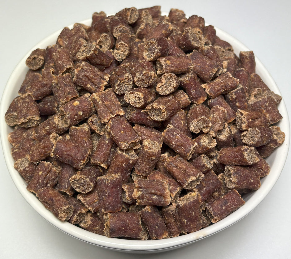 A white bowl filled with GoPetPlace bite-sized dried beef nibbles for dogs