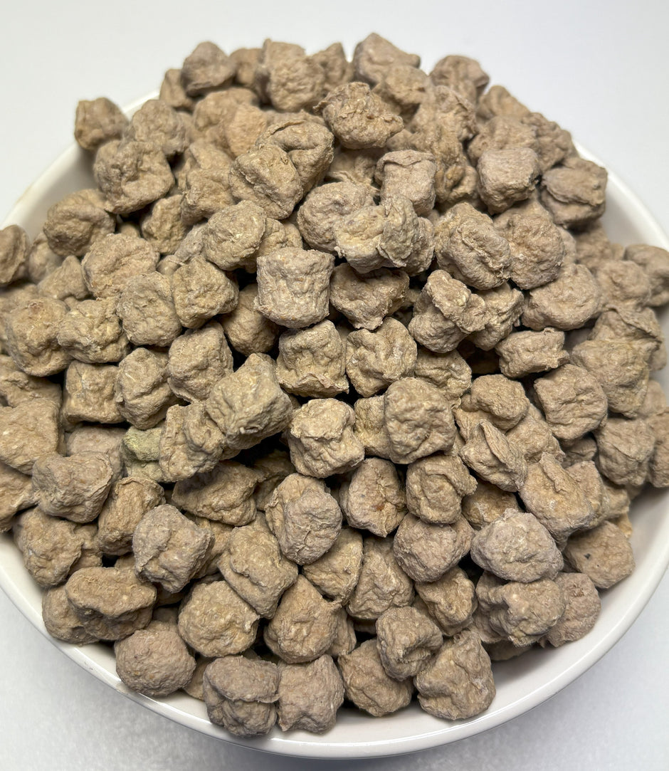 Bowl filled with GoPetPlace dried chicken meatball dog treats, overhead view