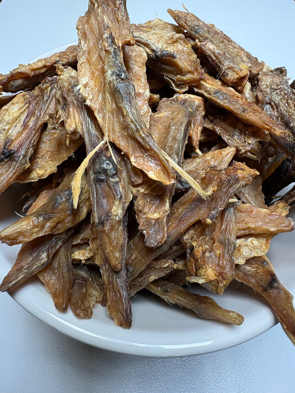 Dried chicken wing tips piled in a white bowl, showing their natural golden-brown colour and texture