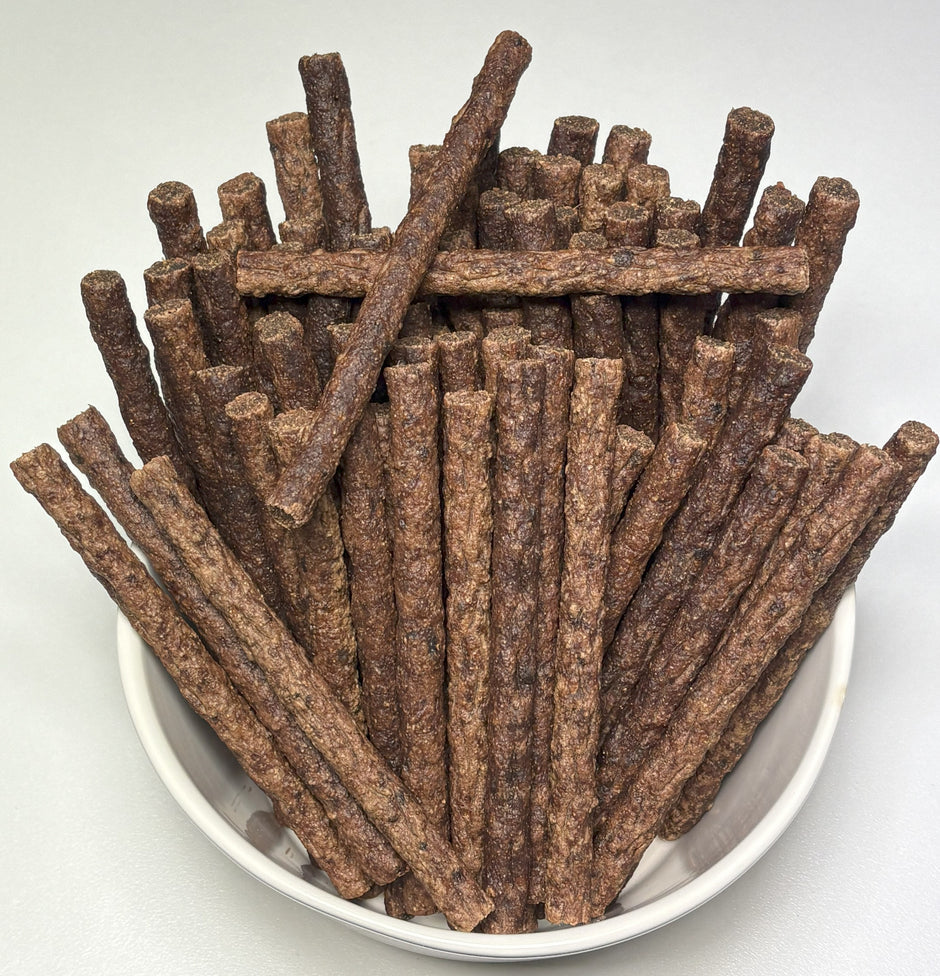 A white bowl filled with GoPetPlace beef mini sticks for dogs, viewed from above