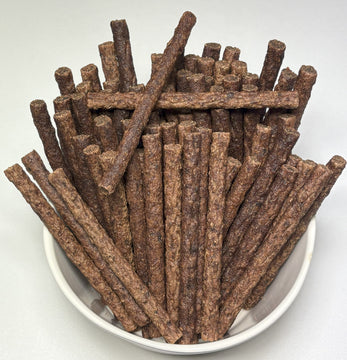 A white bowl filled with GoPetPlace beef mini sticks for dogs, viewed from above