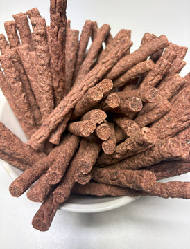 Overhead view of a white bowl filled with GoPetPlace kangaroo mini sticks dog treats