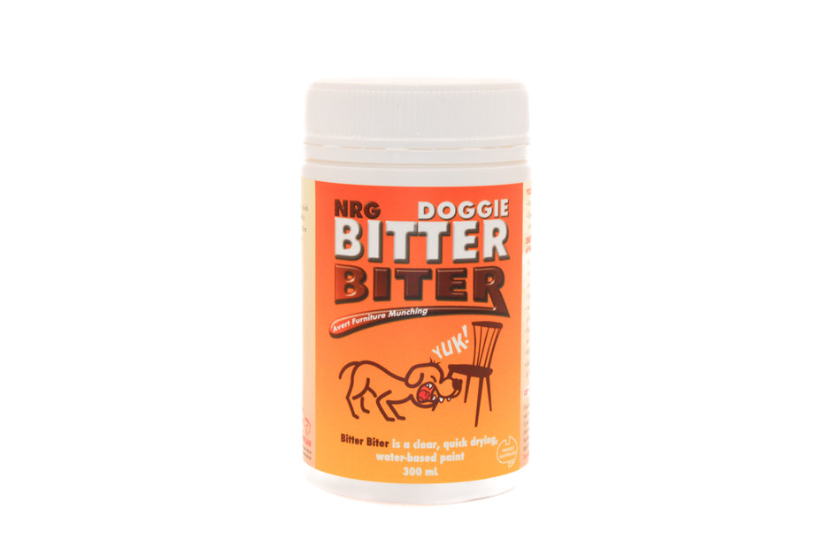 White 300 ml tub of NRG Doggie Bitter Biter anti-chew paint with orange label featuring a cartoon dog recoiling from a chair leg