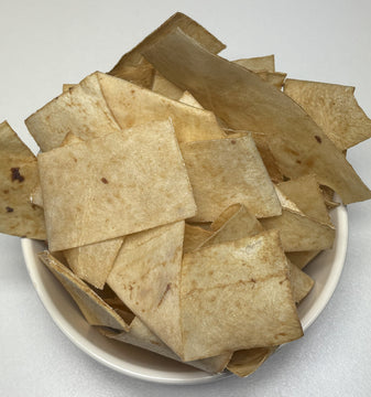 Bowl of GoPetPlace beef flavour rawhide chips, pale natural colour, overhead view