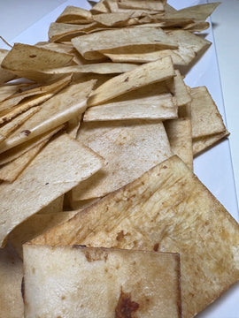 Rawhide chips spread out on a white surface showing varied chip sizes and natural colouring