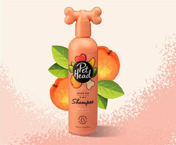 Pet Head Quick Fix 2-in-1 Dog Shampoo peach fragrance 300ml bottle with bone-shaped pump cap, styled against a peachy background with peach fruit and leaves