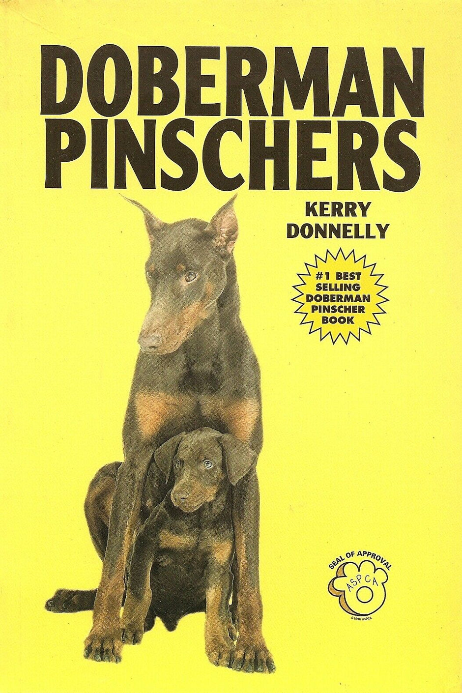 Front cover of Doberman Pinschers by Kerry Donnelly, showing an adult Doberman and a puppy on a yellow background