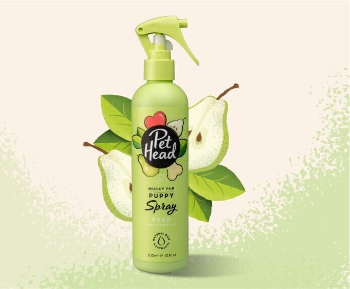 Pet Head Mucky Pup Puppy Spray 300ml in a green trigger-spray bottle, surrounded by illustrated pear and leaf graphics on a light background.