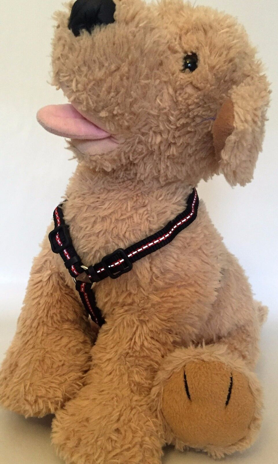 Front view of GoPetPlace black adjustable puppy harness with reflective thread, fitted on a small toy dog stuffy