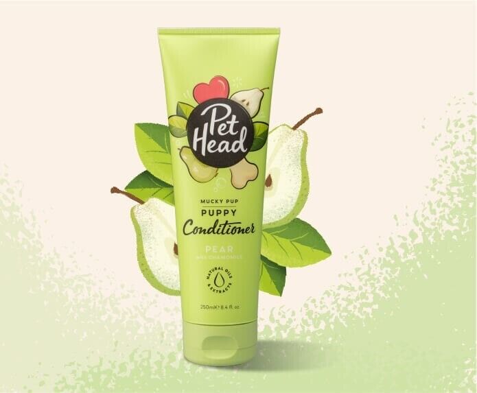 Pet Head Mucky Pup Puppy Conditioner 250ml tube in light green packaging, surrounded by illustrated pear and leaves on a pale background.
