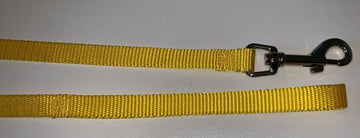 Yellow nylon dog lead showing woven webbing strap and metal trigger-snap clip, laid flat on a white surface.
