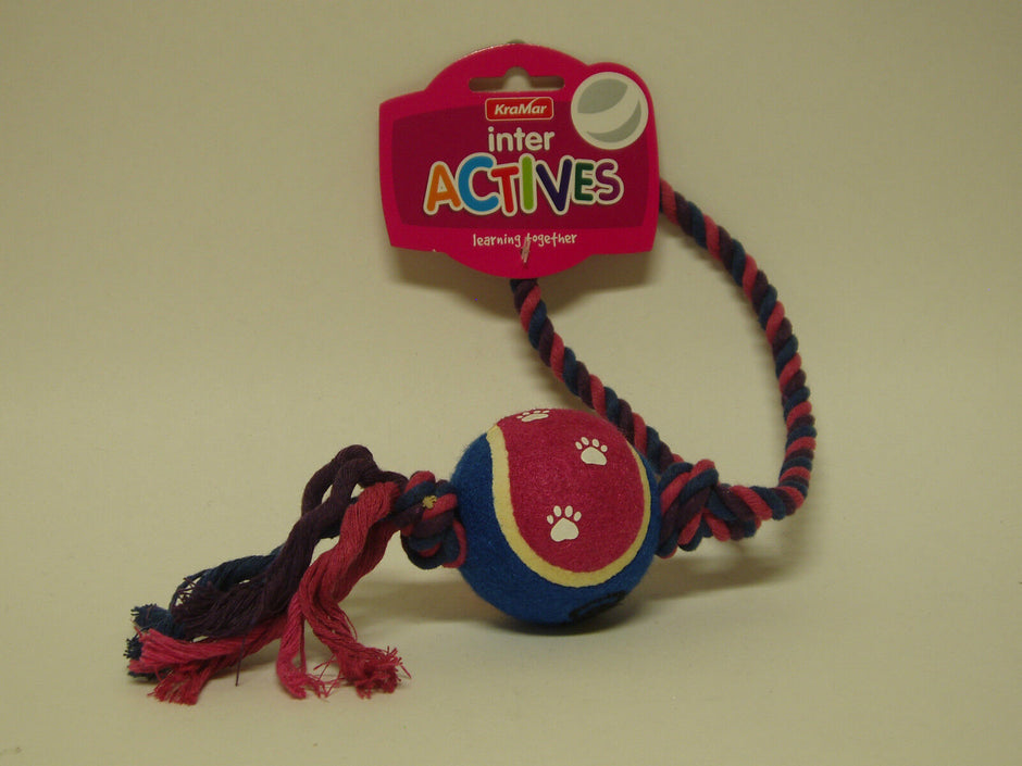 KraMar Inter Actives Sling Ball dog toy — blue and pink tennis-style ball with paw print design threaded onto a twisted rope with a loop handle, shown on retail card packaging.